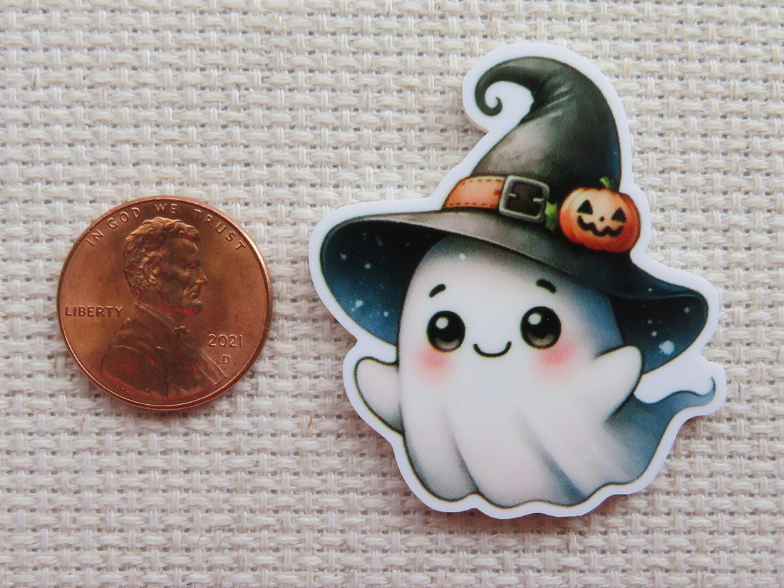 First view of Cute ghost wearing a black witches hat with a tiny carved pumpkin on the brim minder.