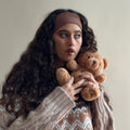 Model wearing Infinity Headband in Mousse while holding teddy bear.